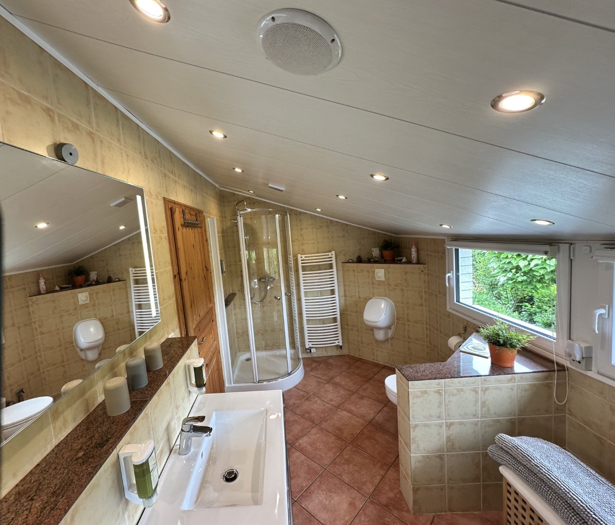 Badezimmer im Dachgeschoss mit Dusche und Fenster zum Garten